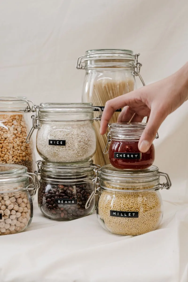Labelled glass jars containing rice, beans, millet and other cupboard ingredients